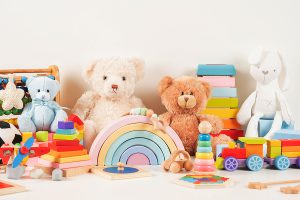 An organized pile of toys, including several teddy bears, ready for a toys donation